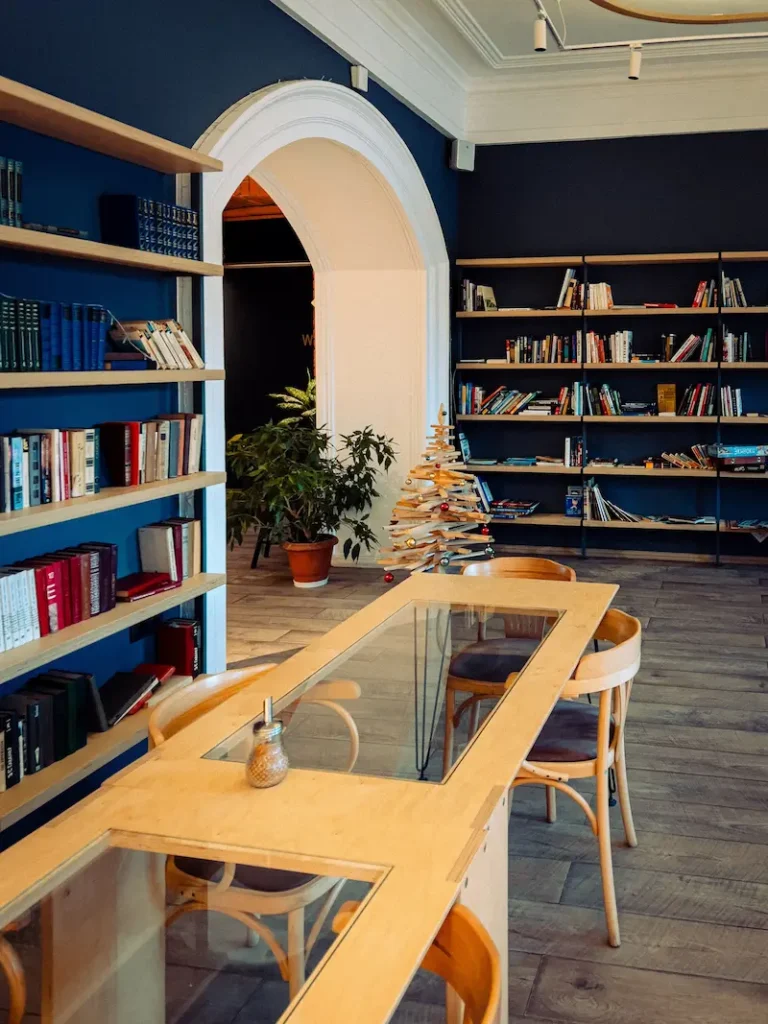 Bookshelves placed in a room with a naivyblue color arches.
